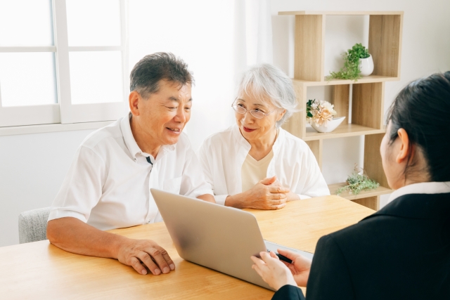 ご夫婦がノートパソコンを見ながらスタッフと相談している様子